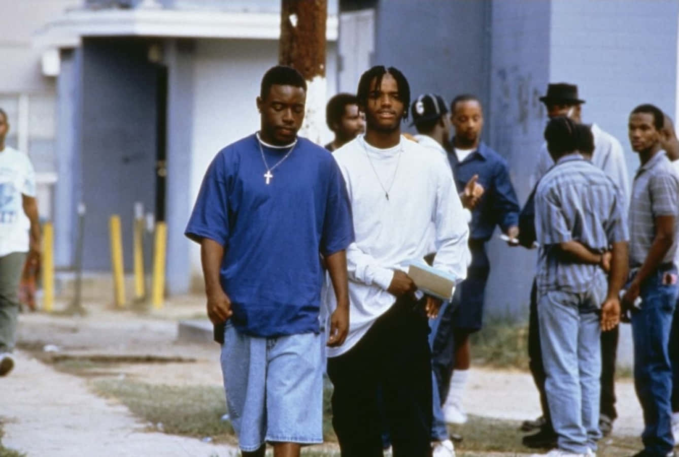 A Group Of Men Walking Down A Street Background