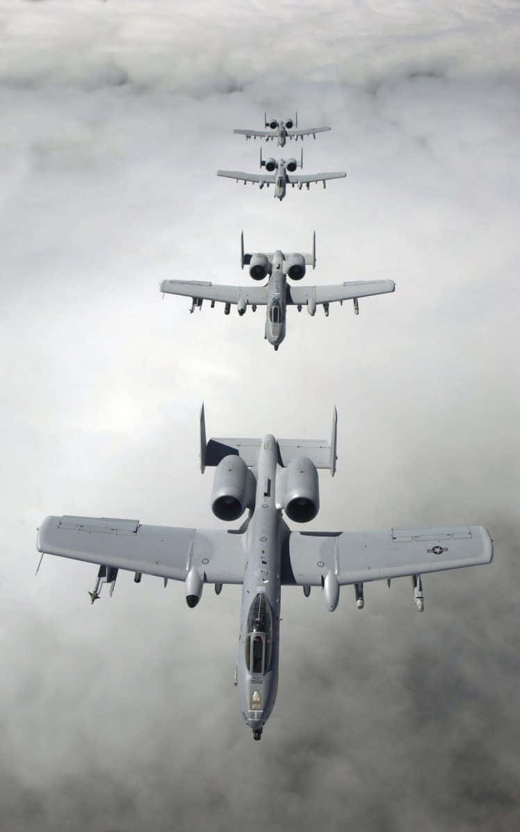 A Group Of Military Jets Flying In The Sky Background