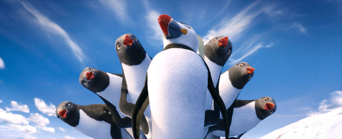 A Group Of Penguins Standing In The Snow