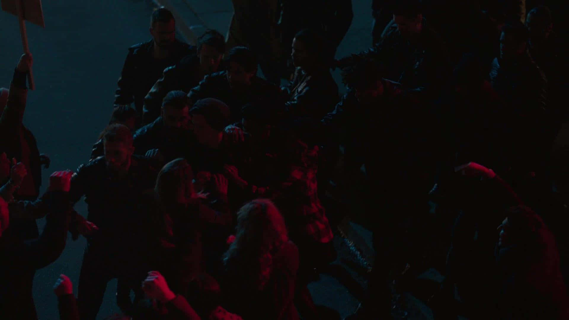 A Group Of People Are Standing In A Street At Night Background