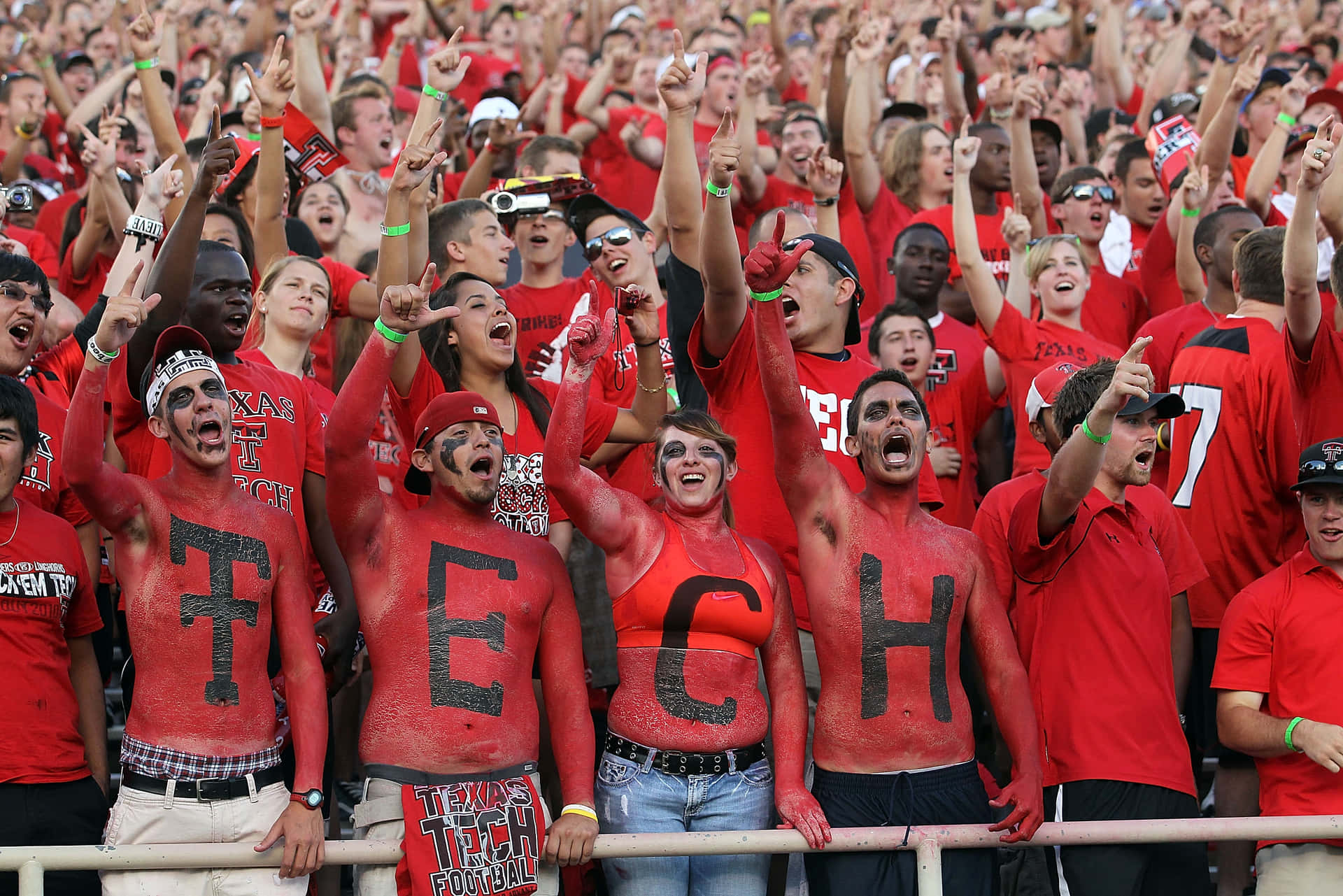 A Group Of People In Red And White With The Word Tech Painted On Their Faces Background