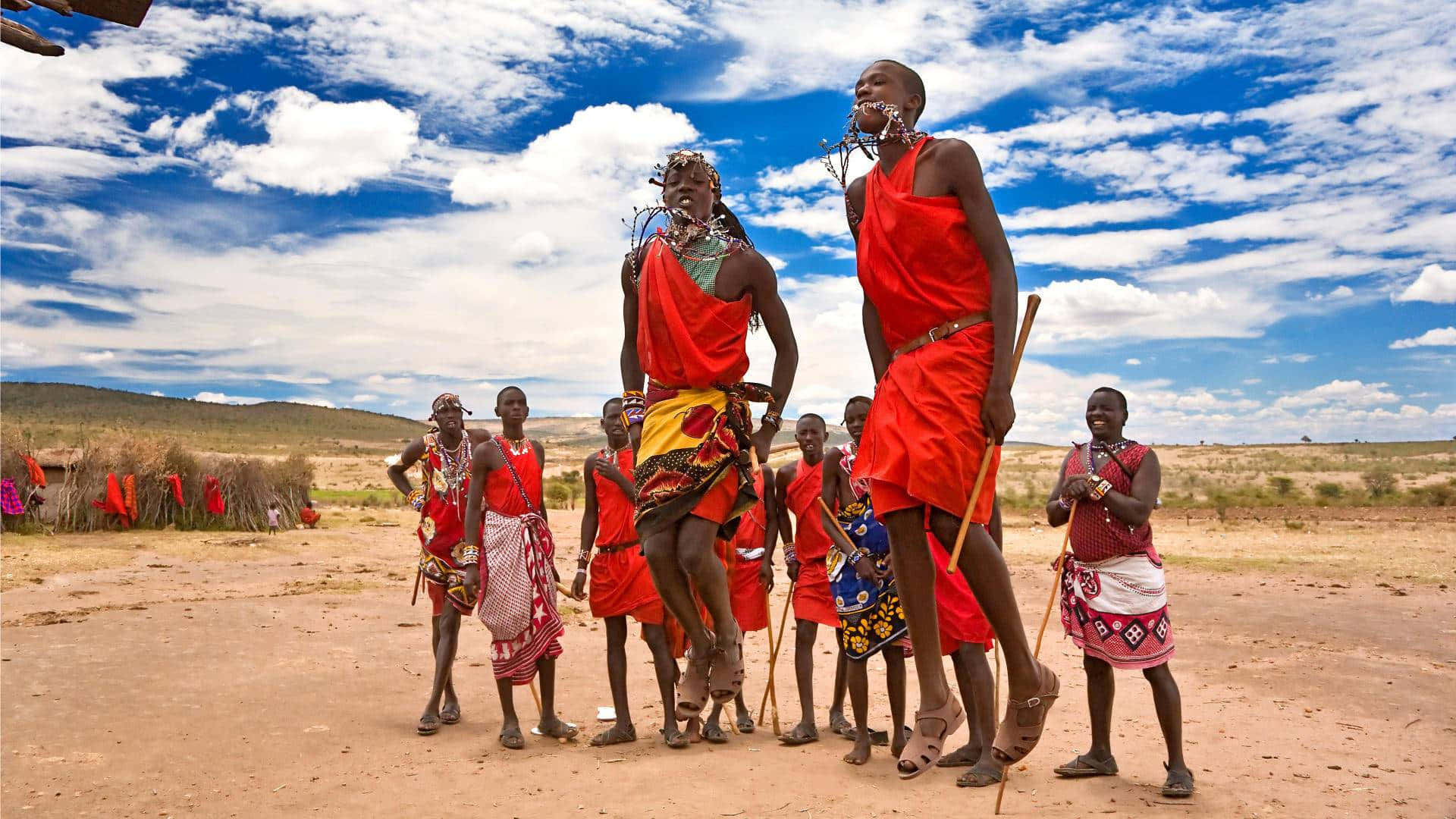 A Group Of People In Red Clothing Are Standing In A Field Background