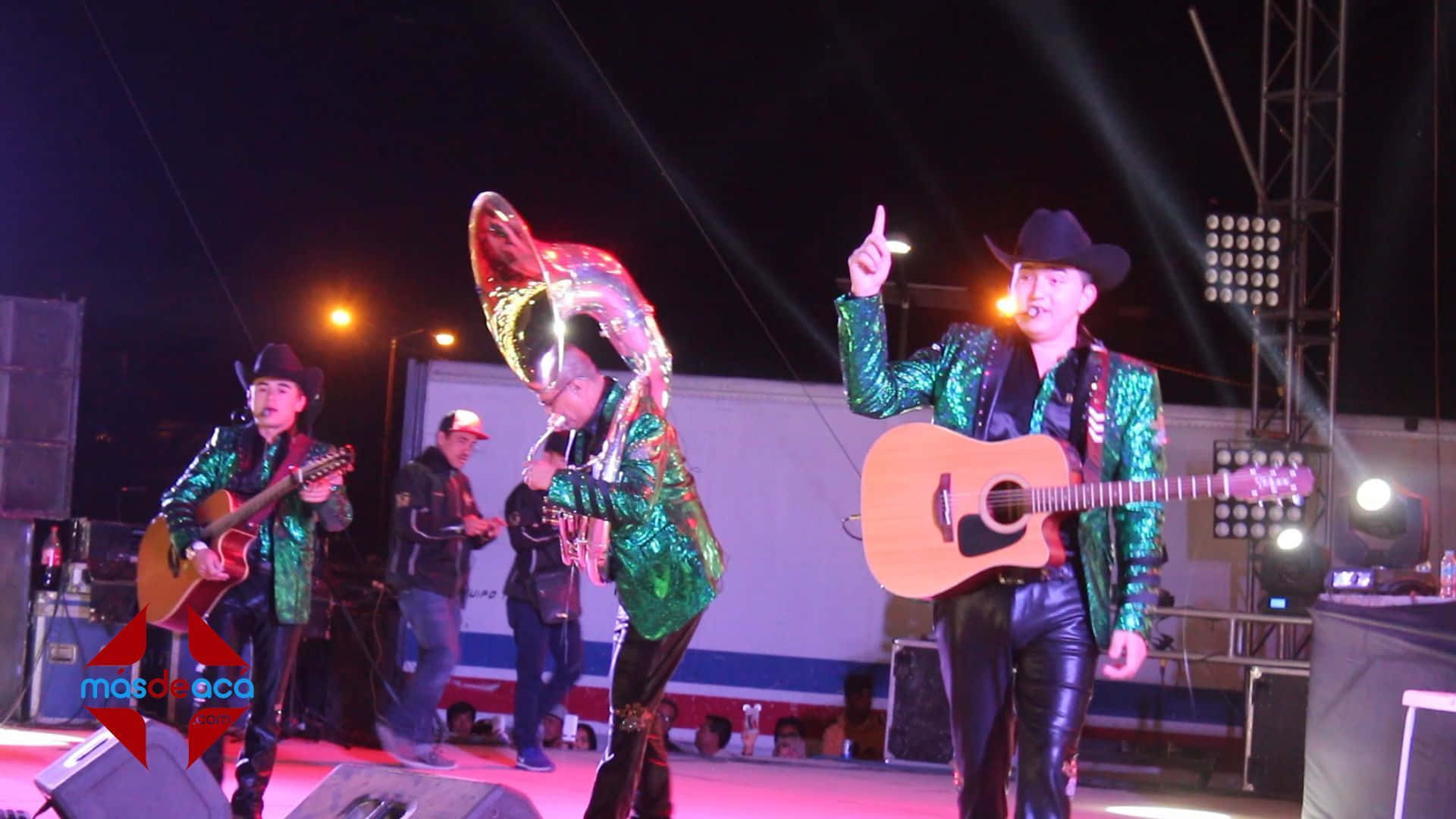 A Group Of People On Stage With Guitars Background