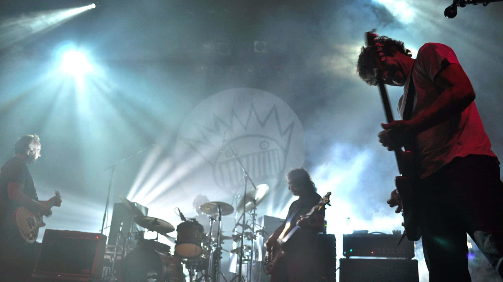 A Group Of People Playing Music On Stage Background