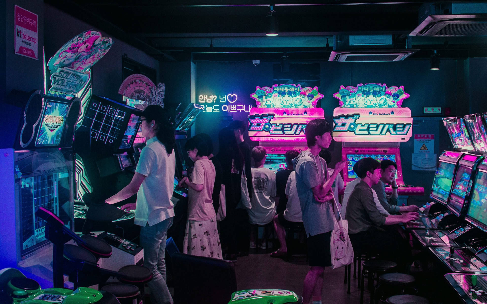 A Group Of People Playing Video Games In A Room Background