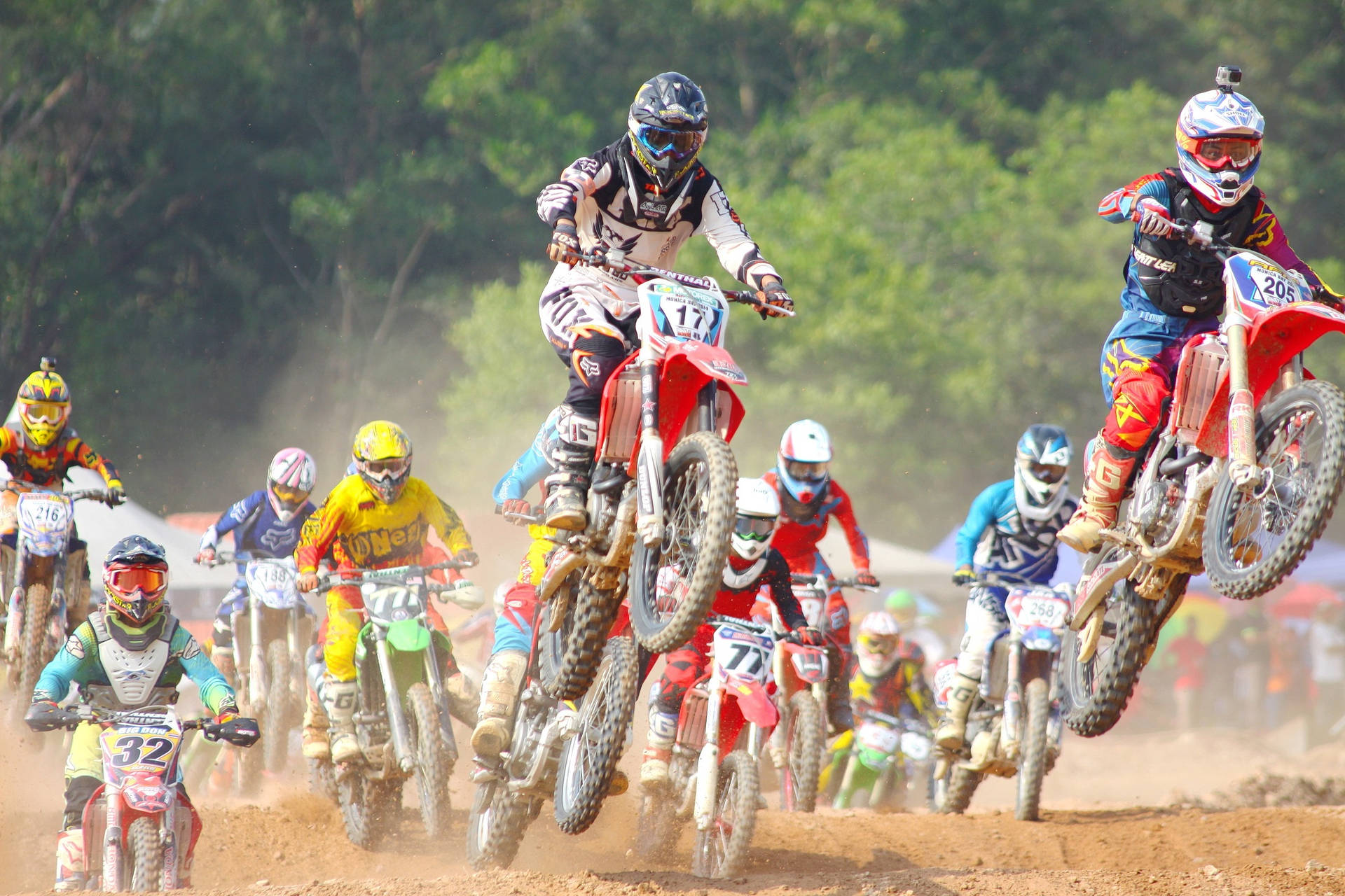 A Group Of People Riding Dirt Bikes Background