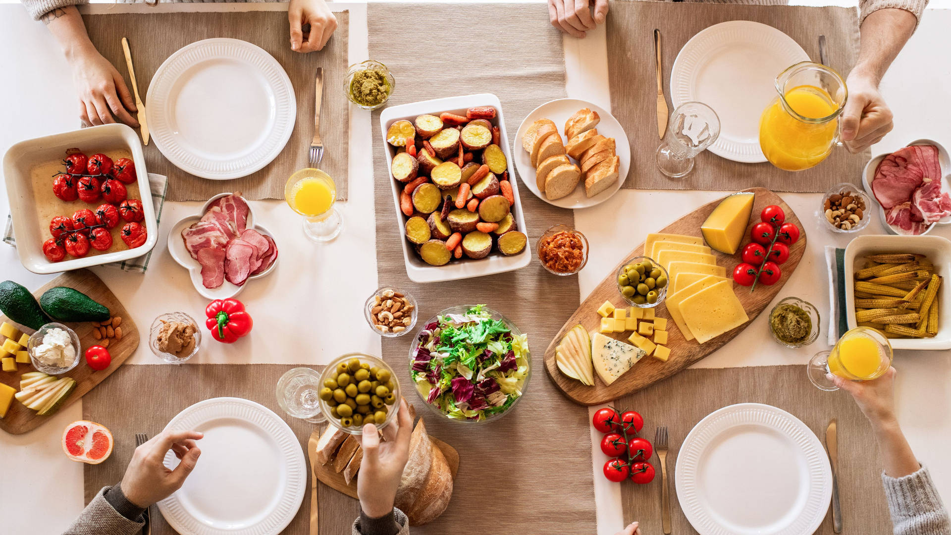 A Group Of People Sitting Around A Table With Food Background