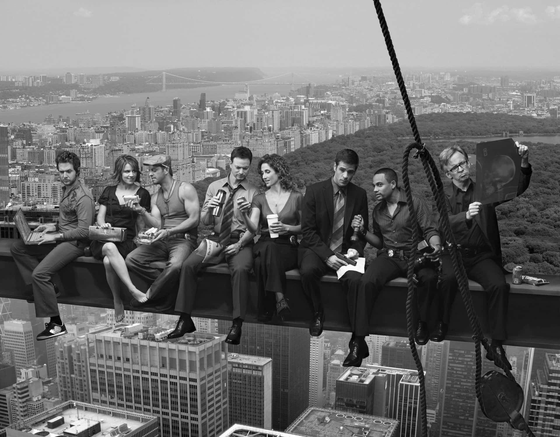 A Group Of People Sitting On A Ledge Overlooking The City Background