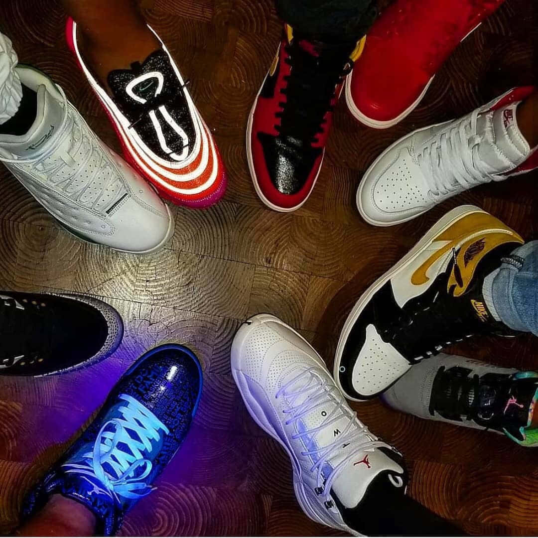 A Group Of People Standing Around A Table With Shoes On Background