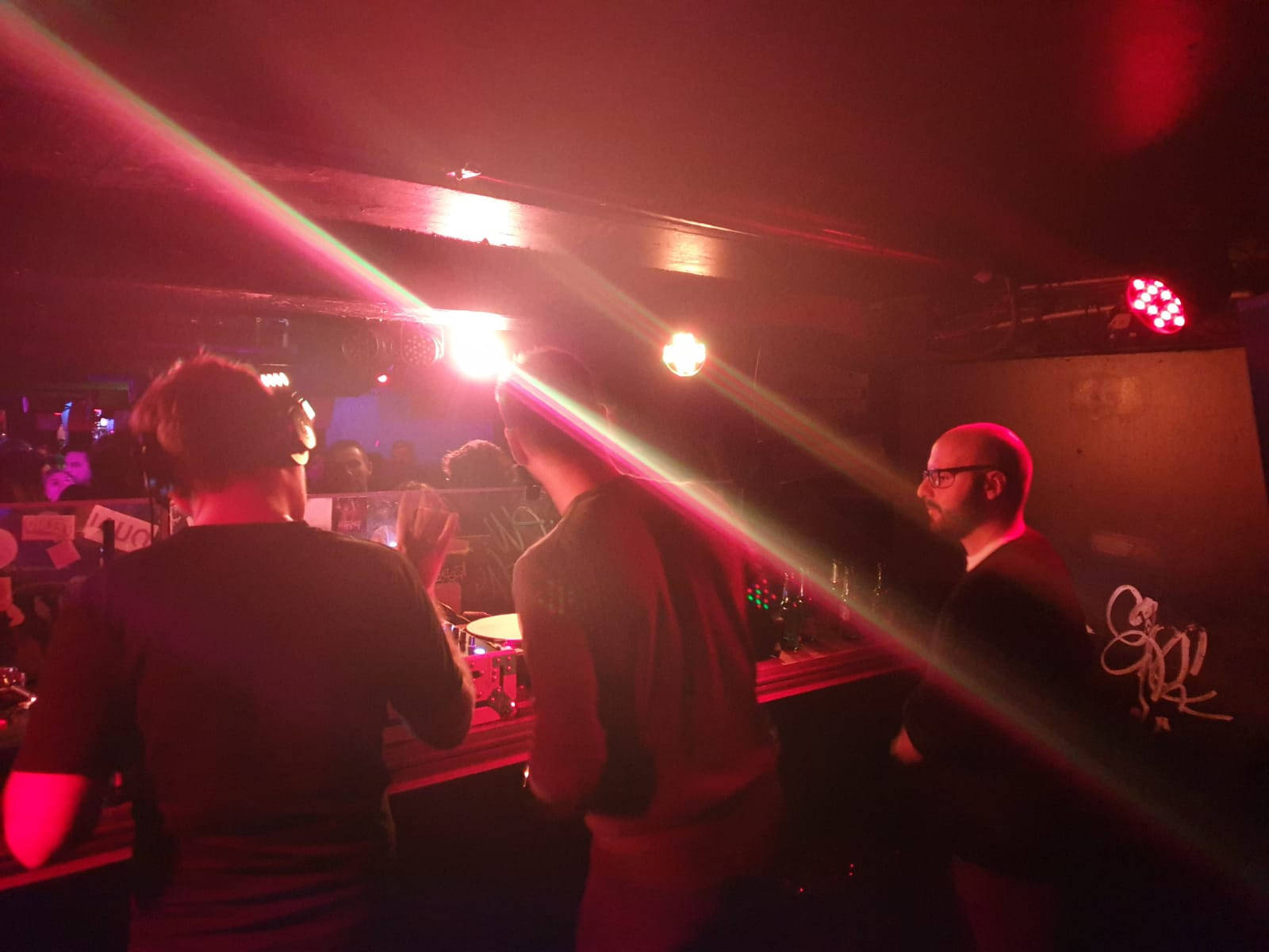 A Group Of People Standing In A Dark Room Background