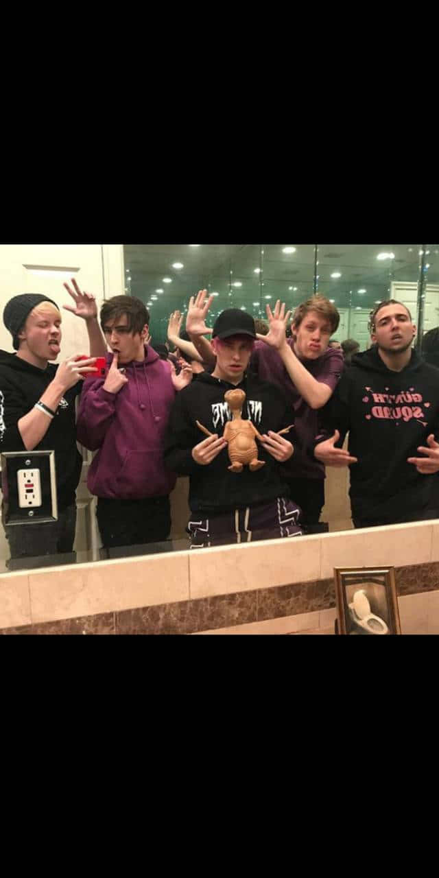 A Group Of People Standing In Front Of A Mirror Background
