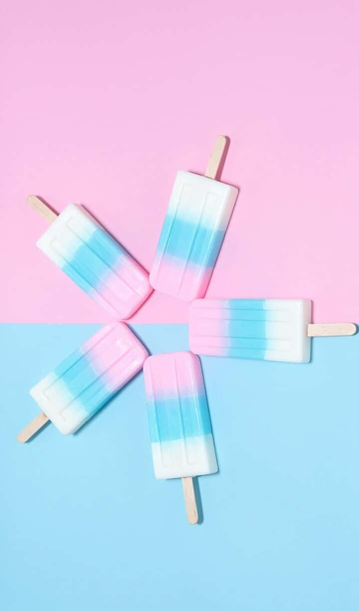 A Group Of Popsicles On A Pink And Blue Background Background