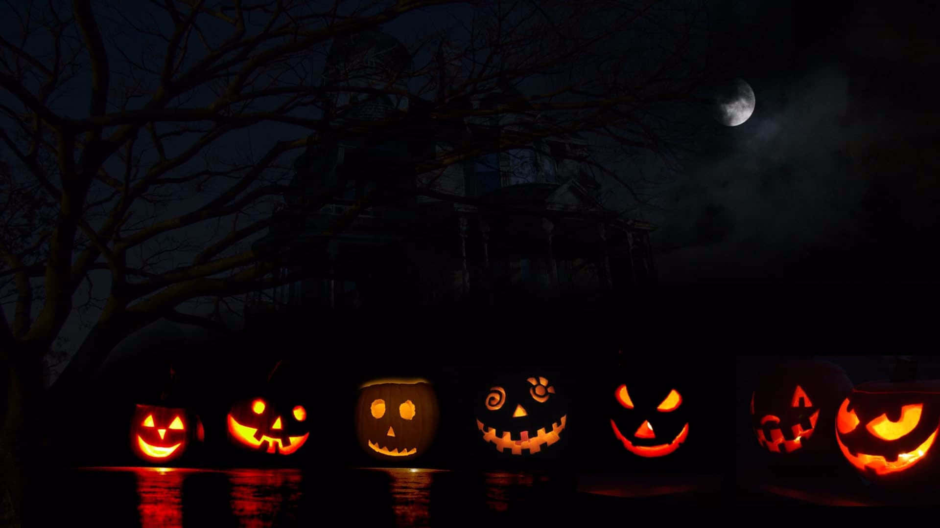 A Group Of Pumpkins With Faces Lit Up Background