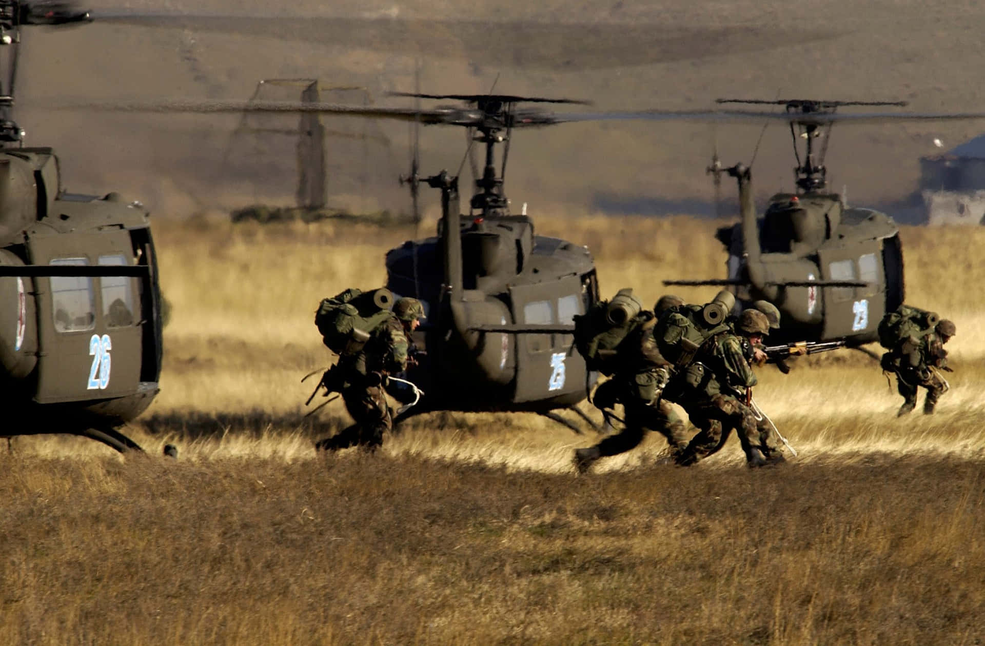 A Group Of Soldiers Running Through A Field