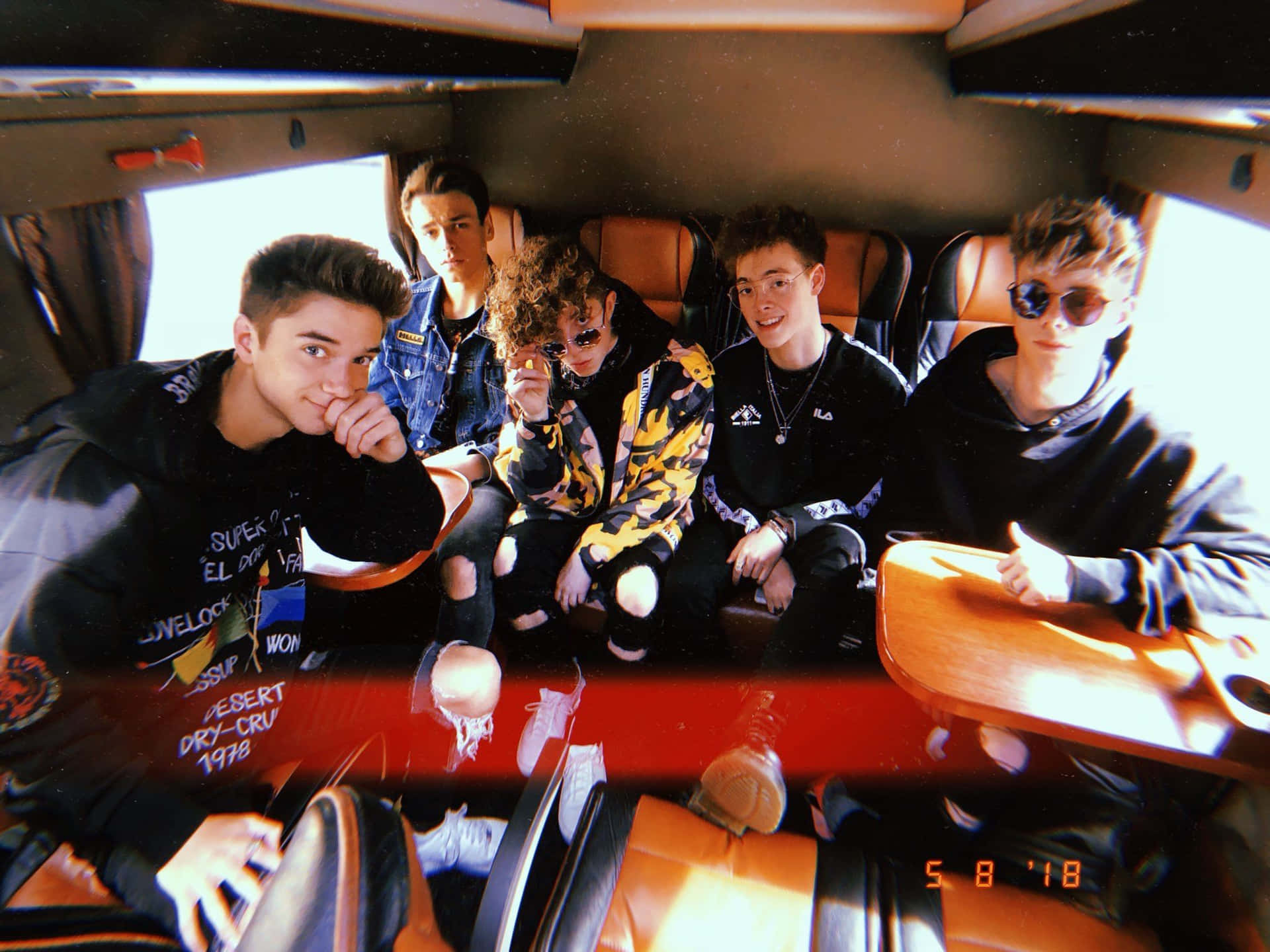 A Group Of Young Men Sitting In A Van Background