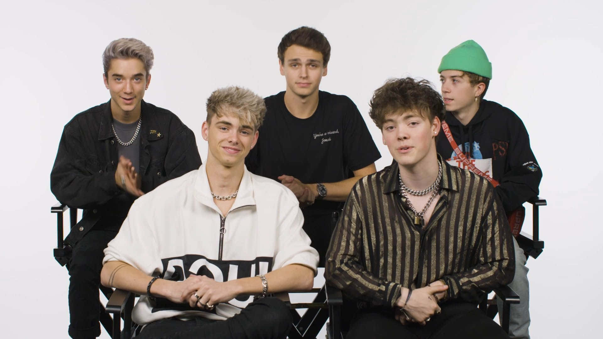 A Group Of Young Men Sitting In Chairs Background