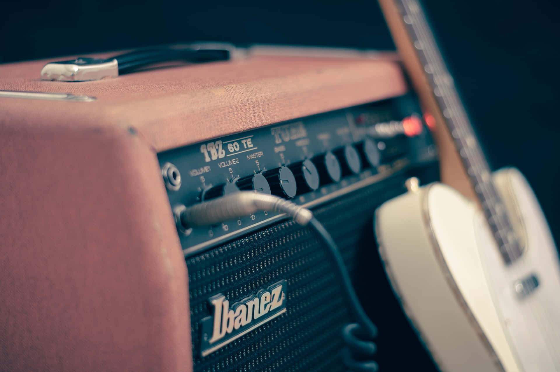 A Guitar Amplifier With A Guitar On It Background