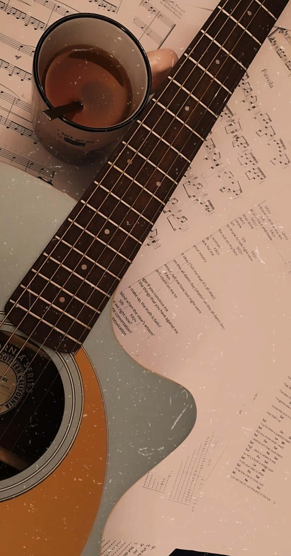 A Guitar And Cup Of Coffee On A Sheet Of Music Background