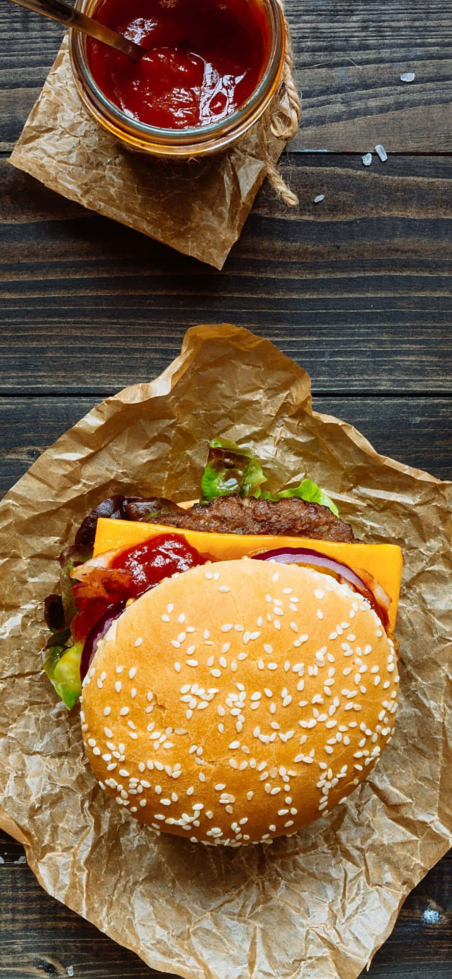 A Hamburger With Ketchup And Mustard On A Brown Paper