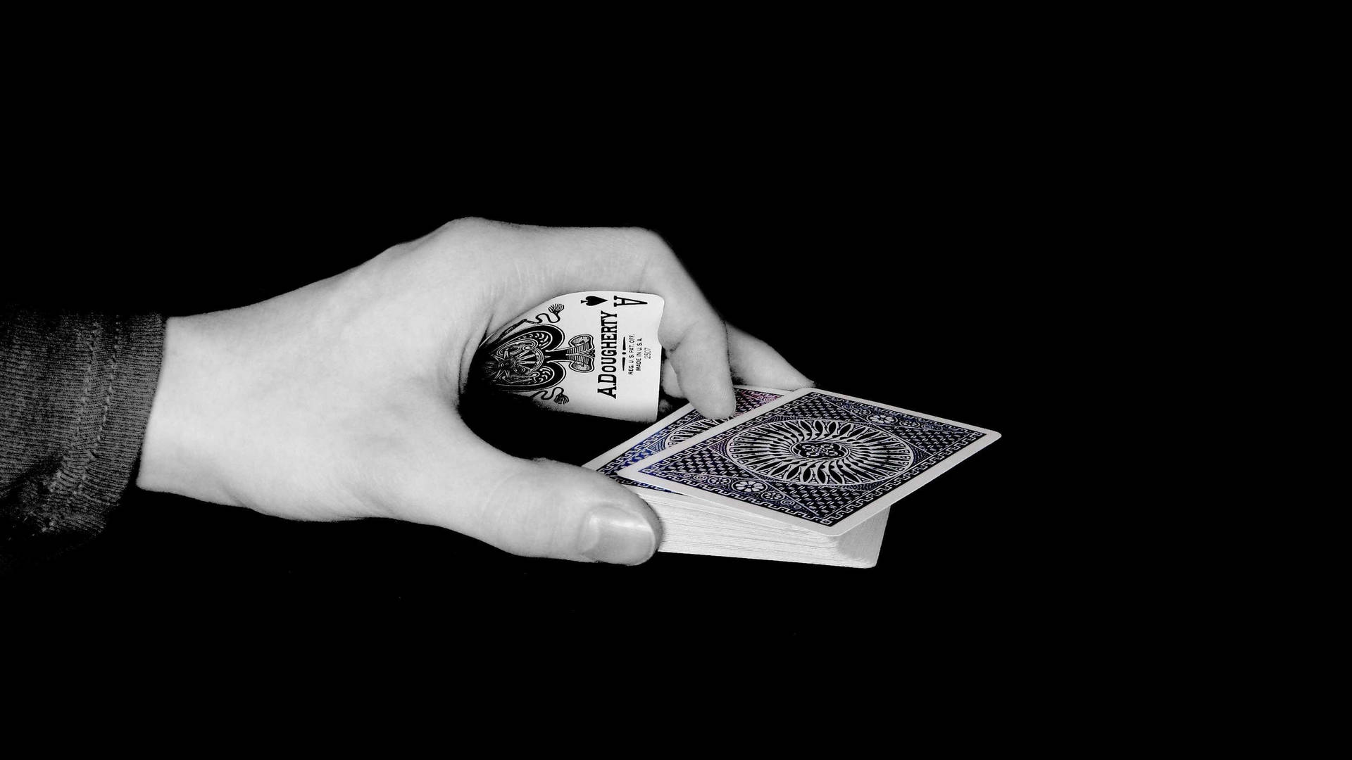 A Hand Holding A Deck Of Cards In Black And White