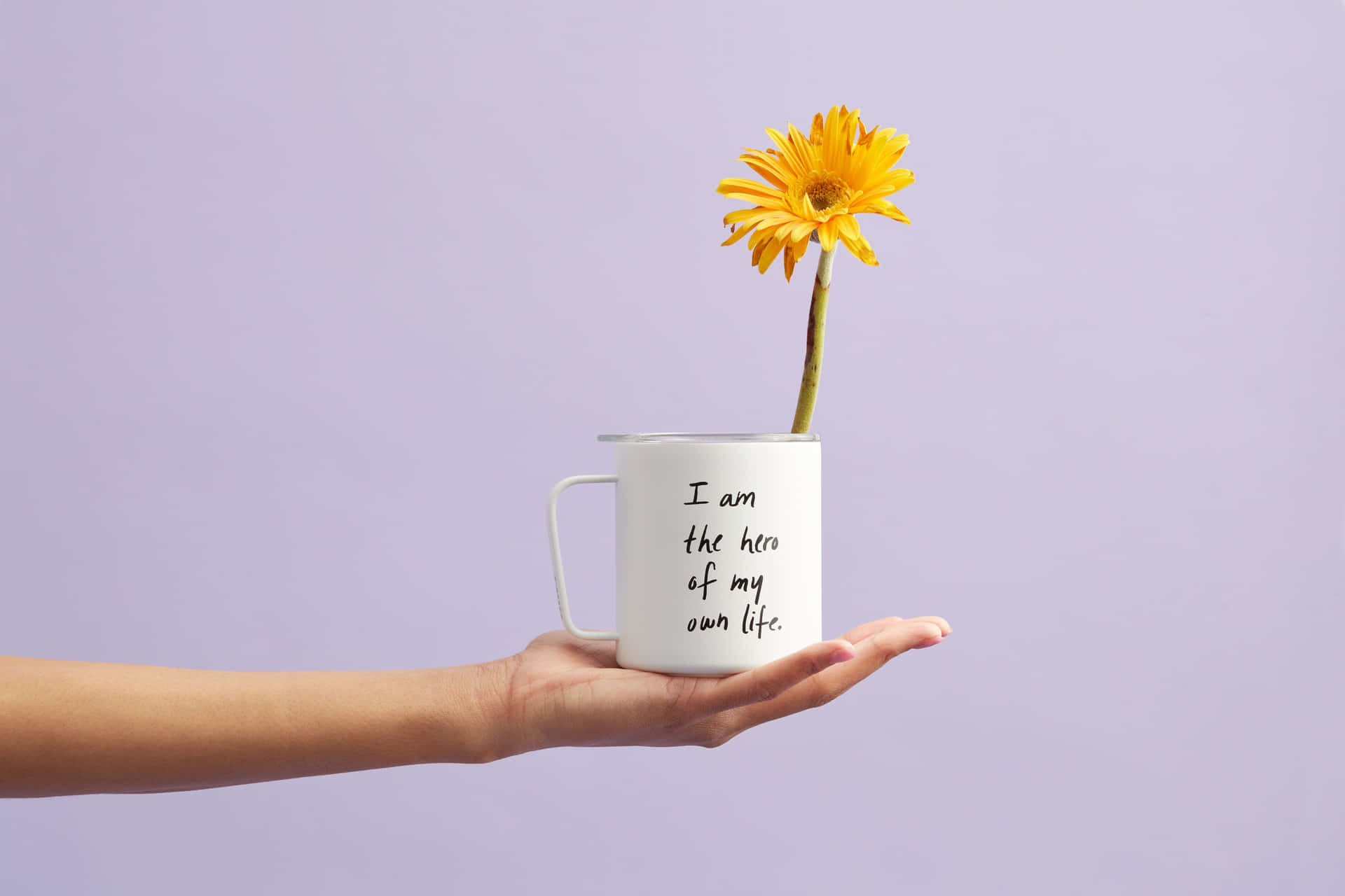 A Hand Holding A Mug With A Flower In It Background