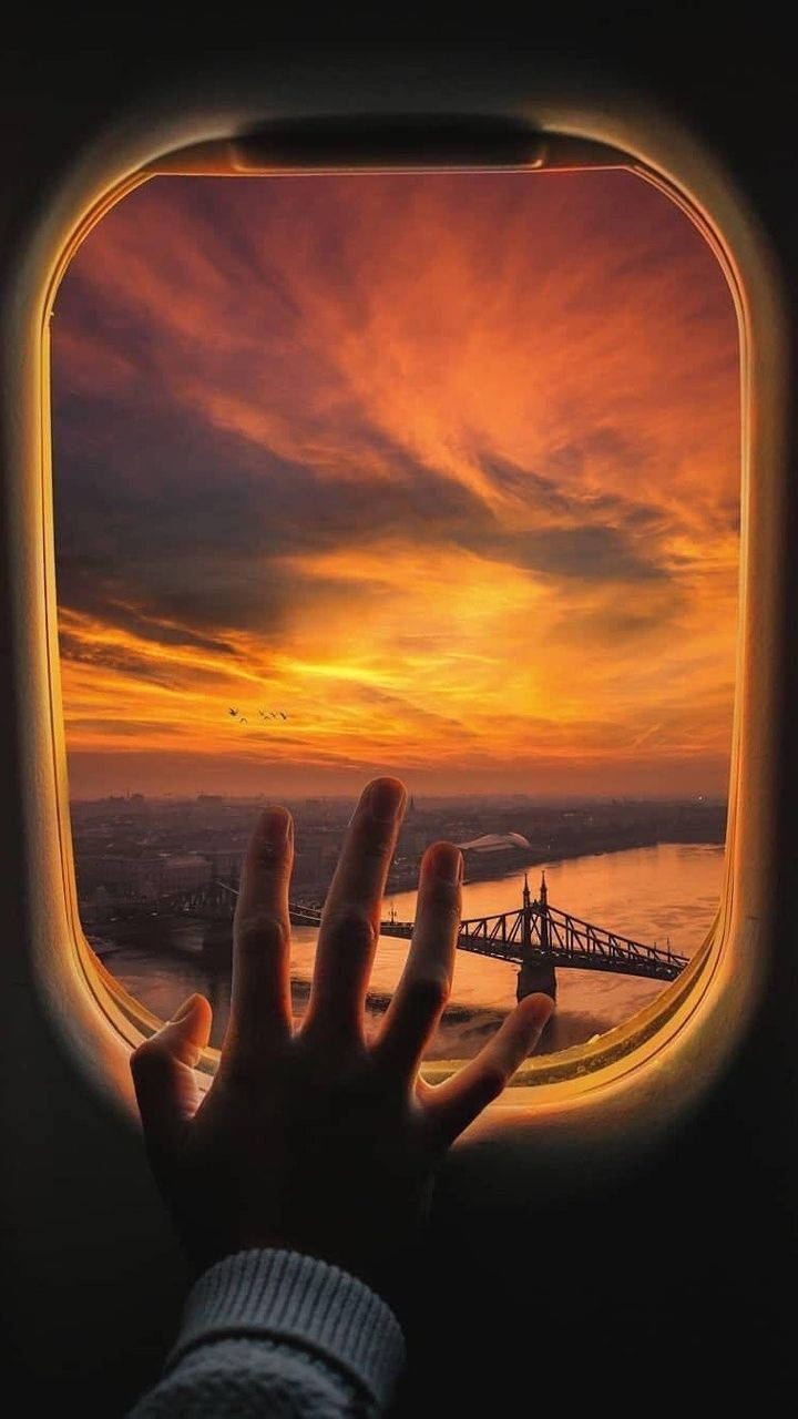 A Hand On A Plane Window Background