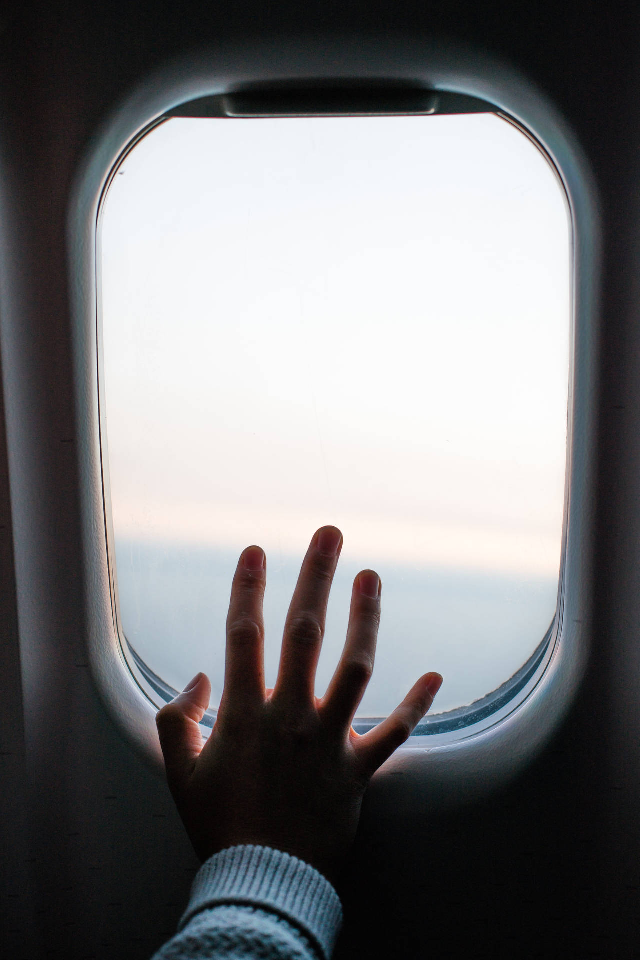 A Hand Touching The Plane Window Background