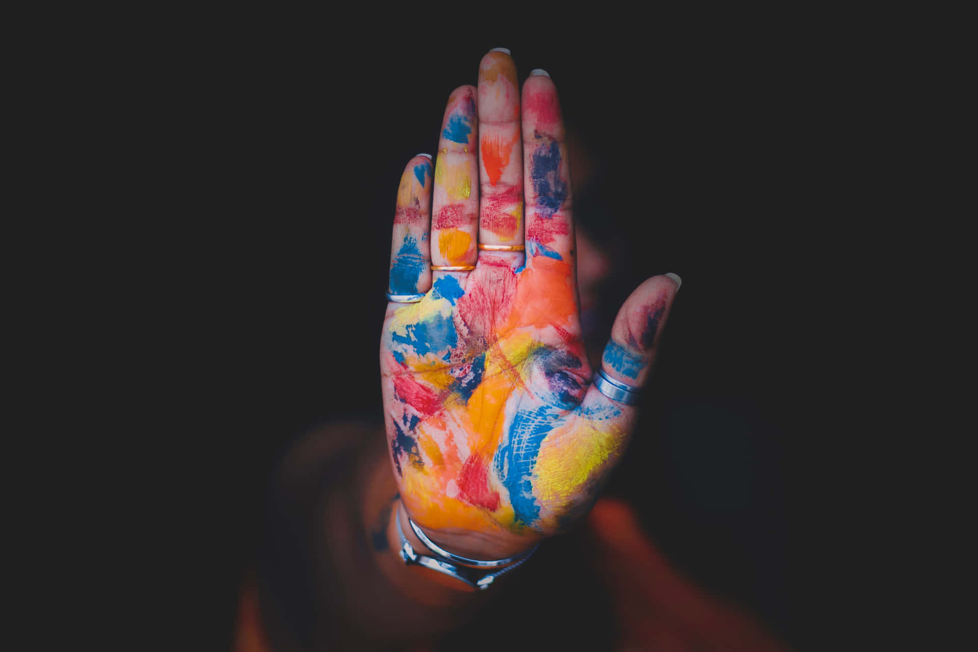 A Hand With Colorful Paint On It Background