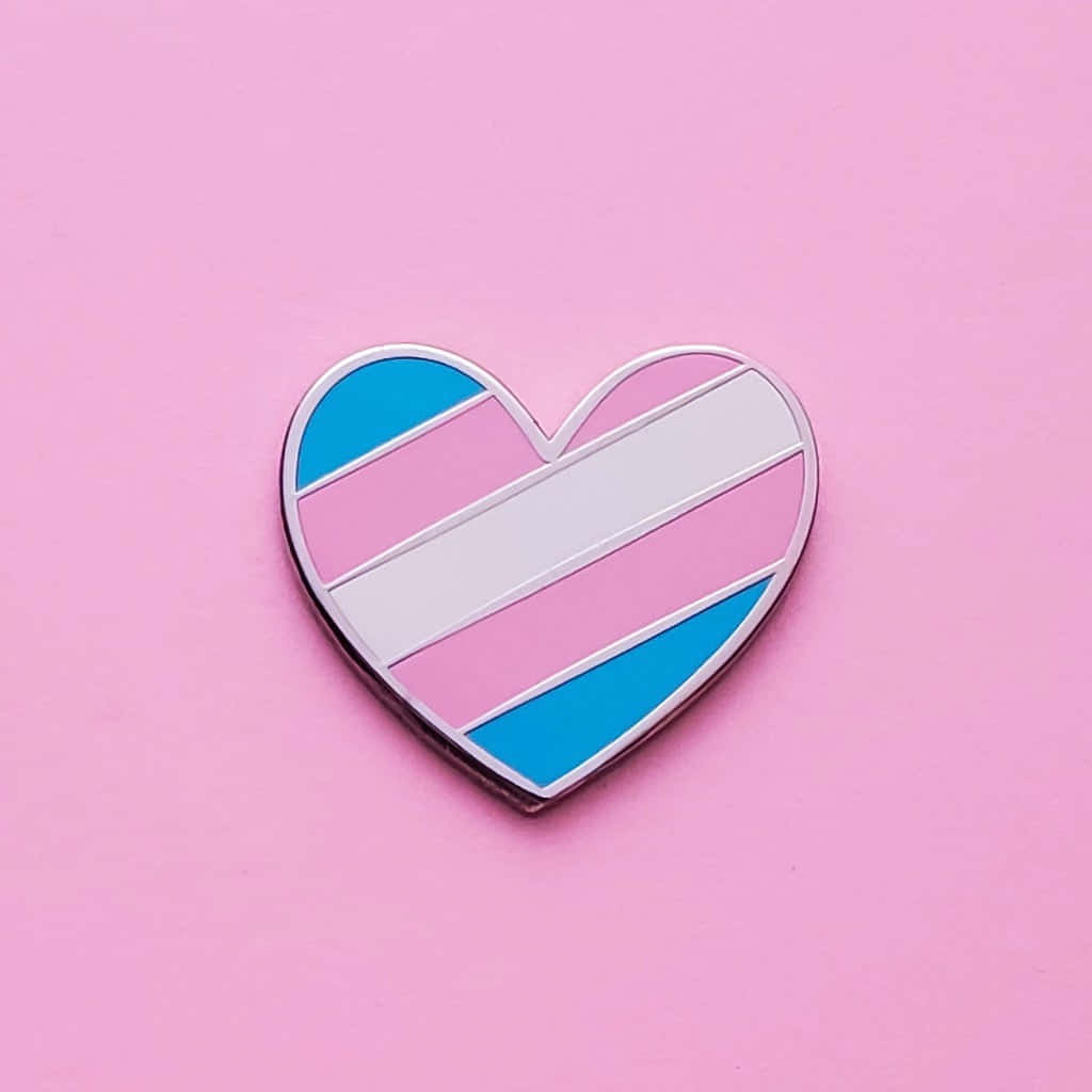 A Heart Shaped Pin With A Rainbow And Blue Stripe Background