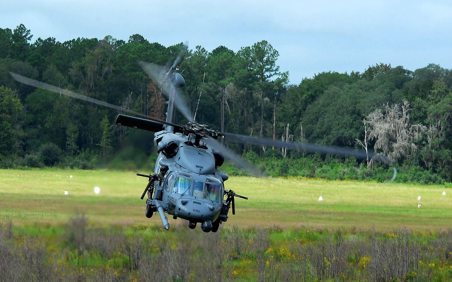 A Helicopter Is Flying Over A Field Background