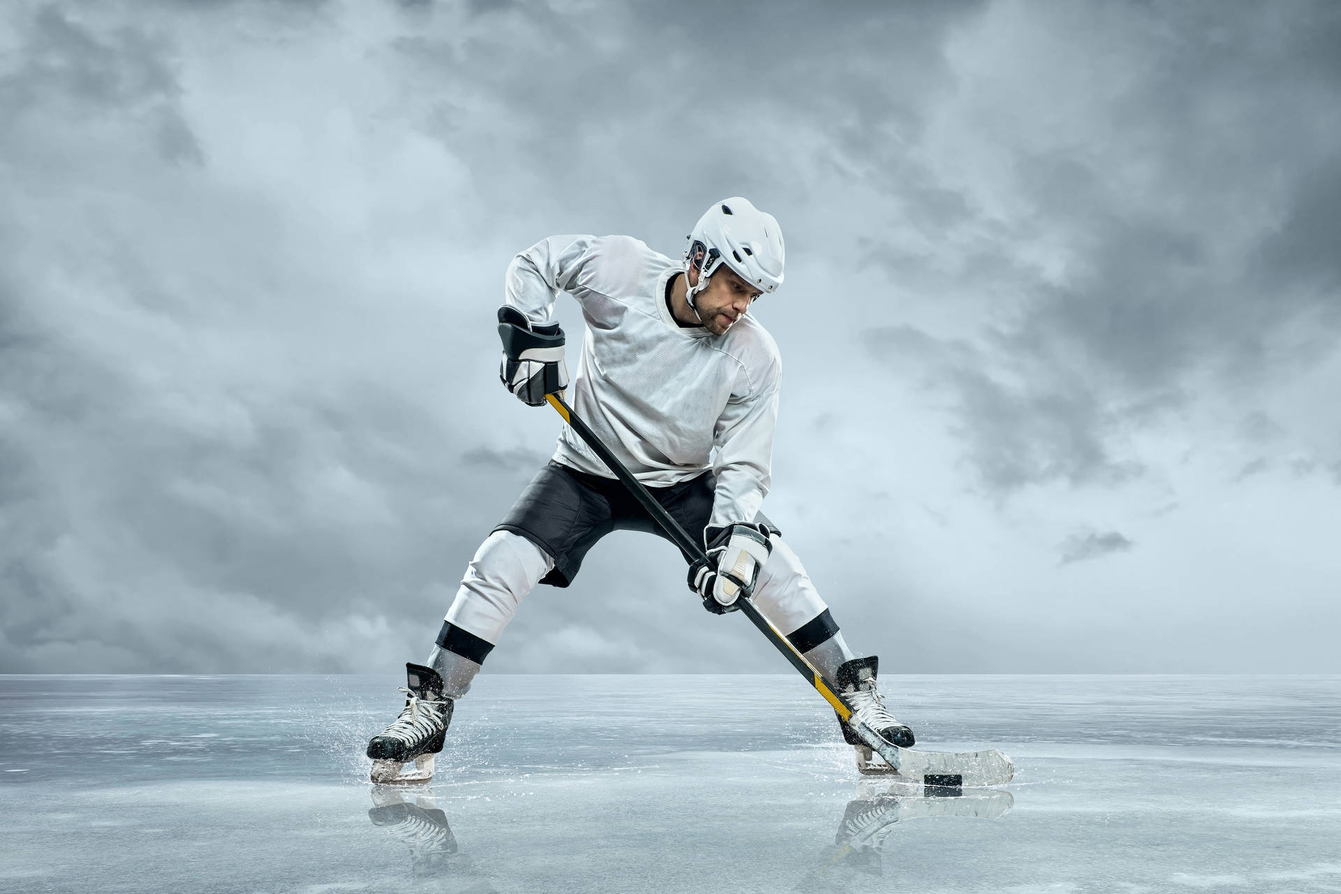 A Hockey Player Is Playing On Ice With A Cloudy Sky Background