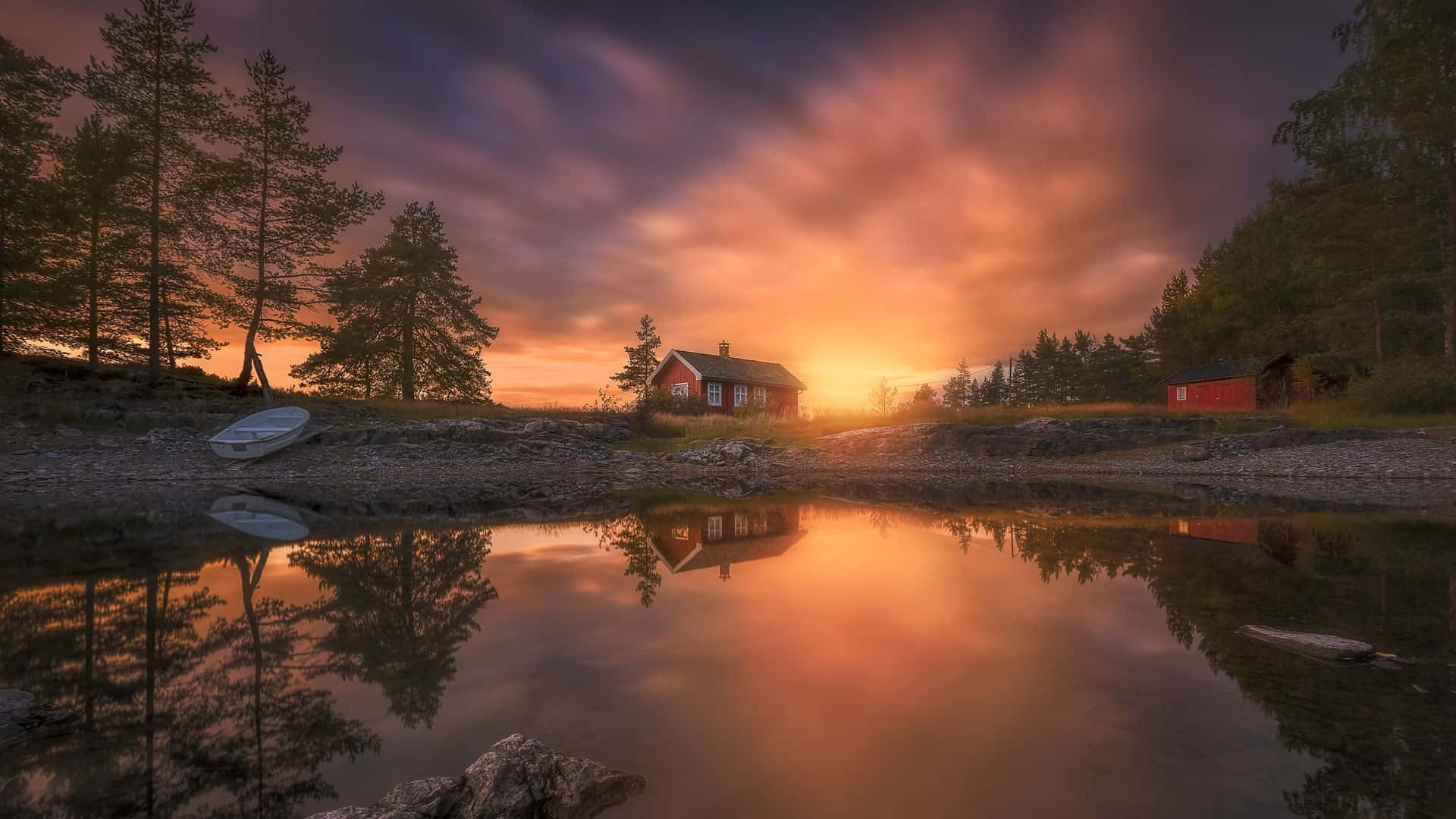 A House Is Reflected In The Water At Sunset