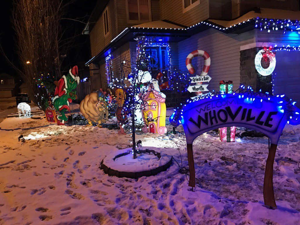 A House With Christmas Lights And Decorations In The Snow Background