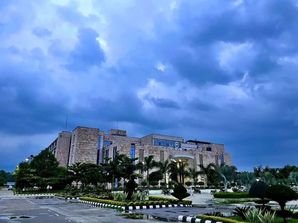 A I I M S Campus Under Stormy Skies Background