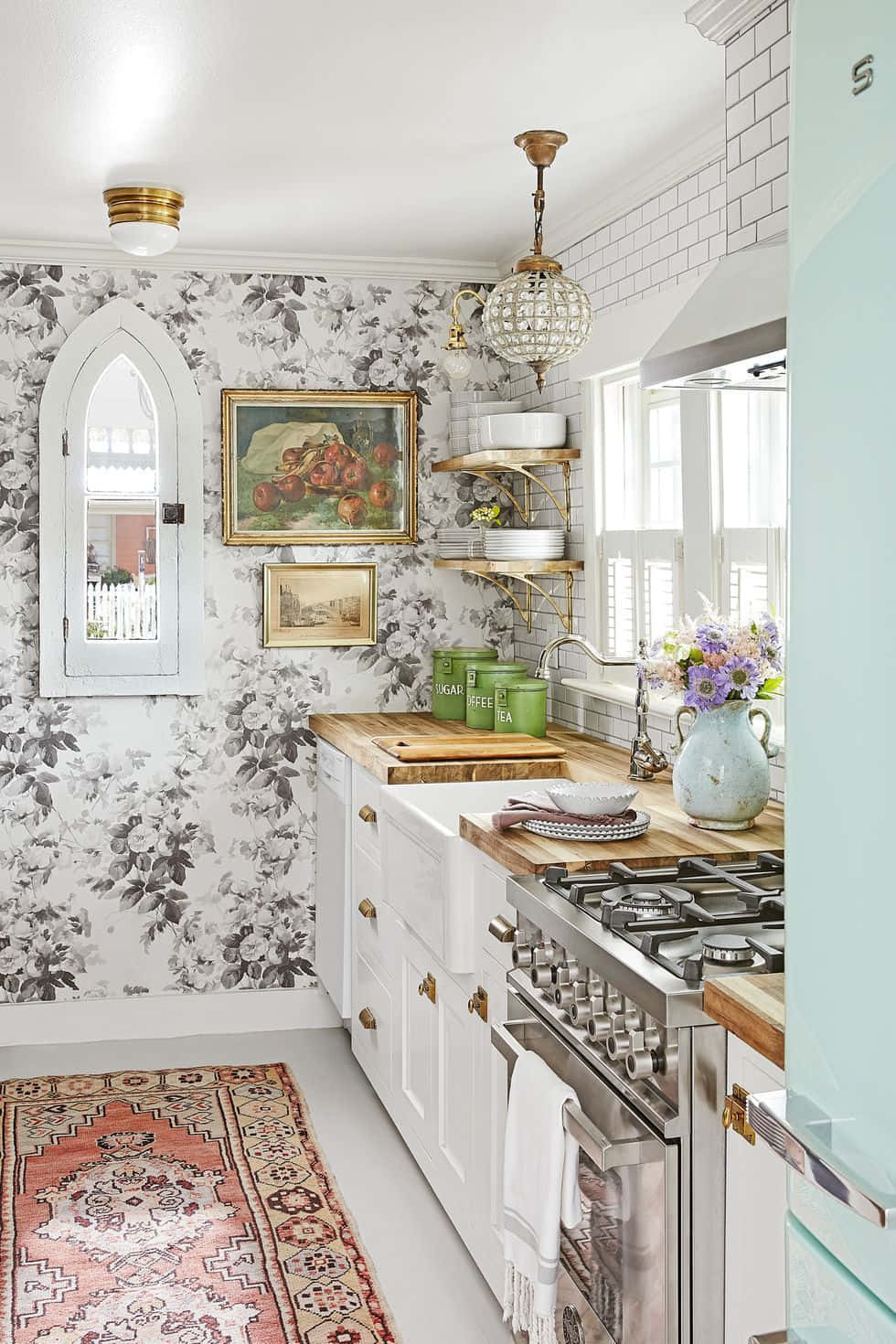 A Kitchen With A Floral Wallpaper And A Green Rug Background