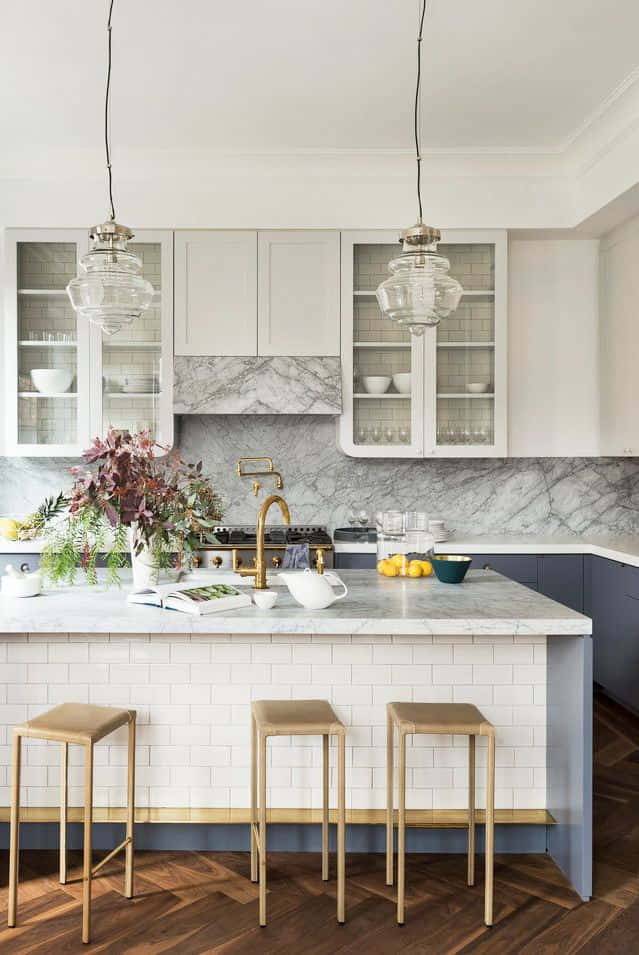 A Kitchen With Marble Counter Tops And Wooden Floors Background