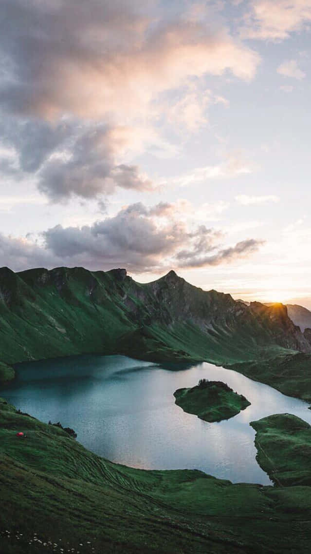 A Lake In The Mountains At Sunset Background