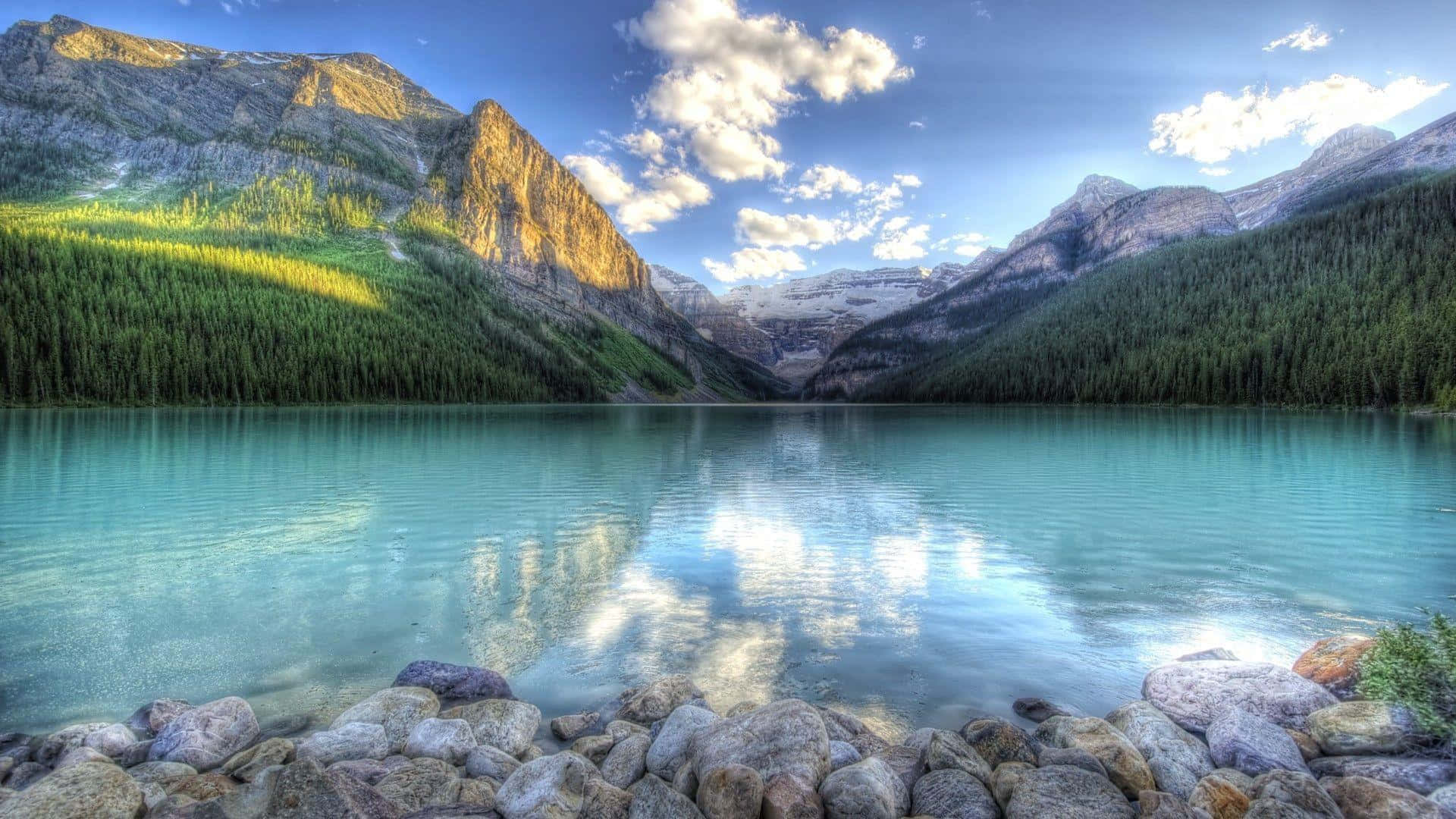 A Lake Surrounded By Mountains And Rocks Background