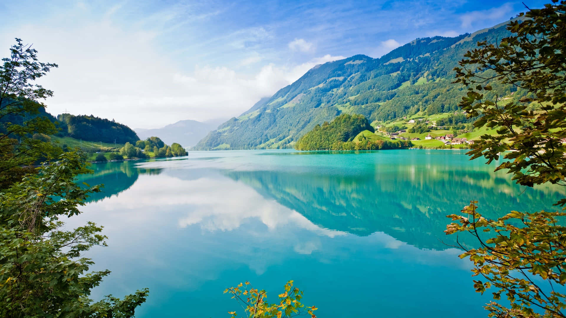 A Lake Surrounded By Mountains And Trees Background