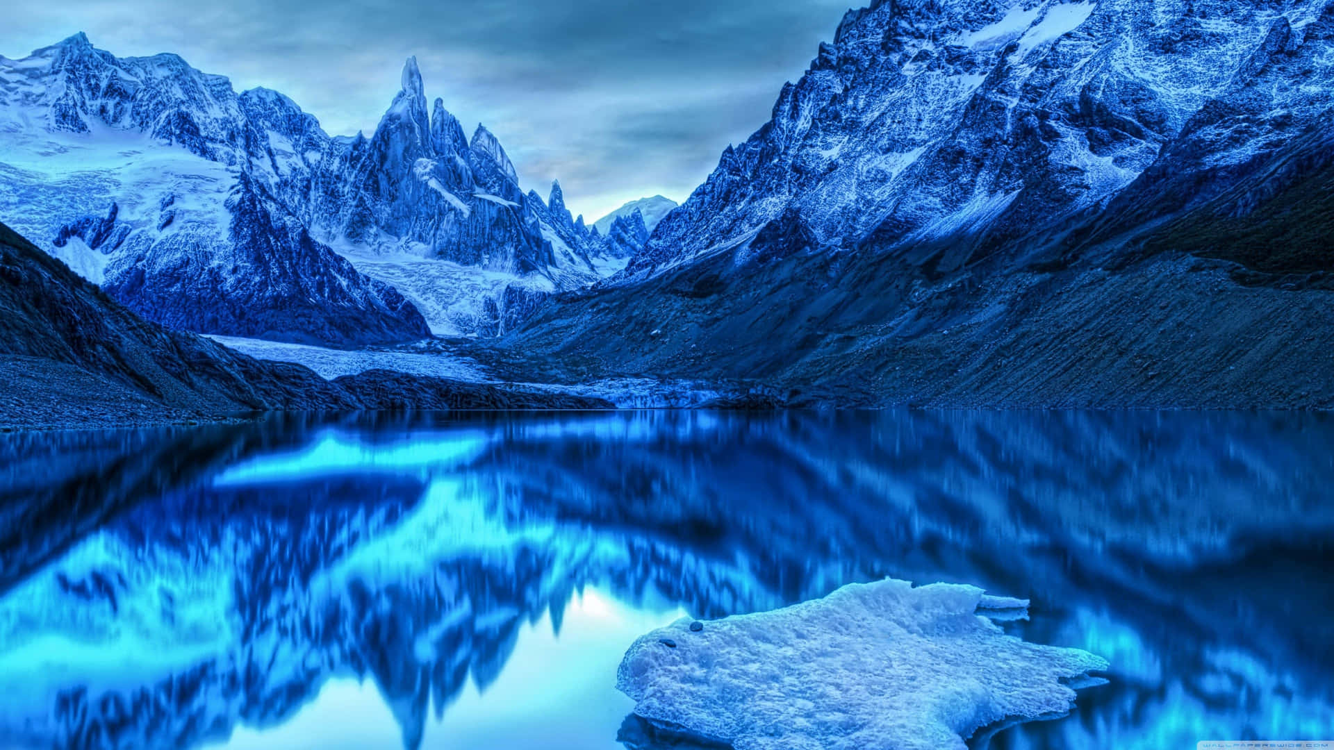 A Lake With Icebergs And Mountains In The Background