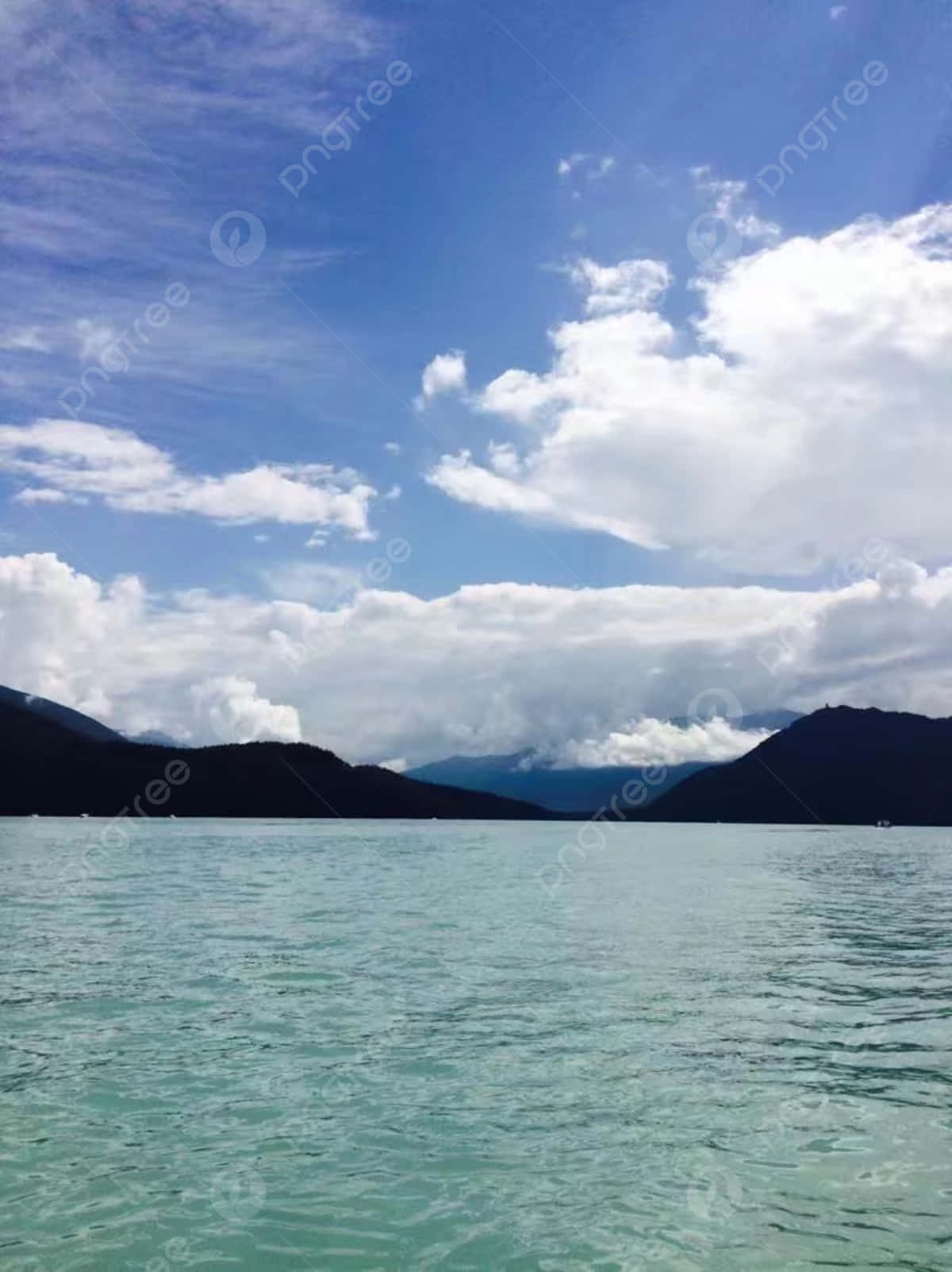 A Lake With Mountains And Clouds In The Background Background