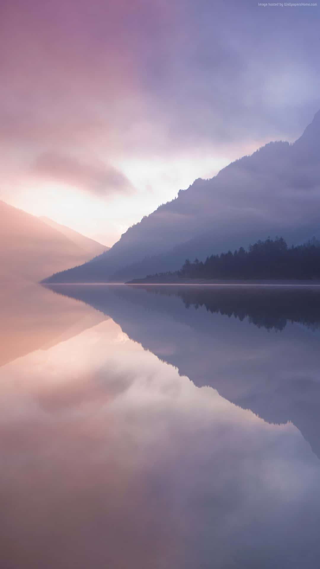 A Lake With Mountains And Fog Reflected In It Background