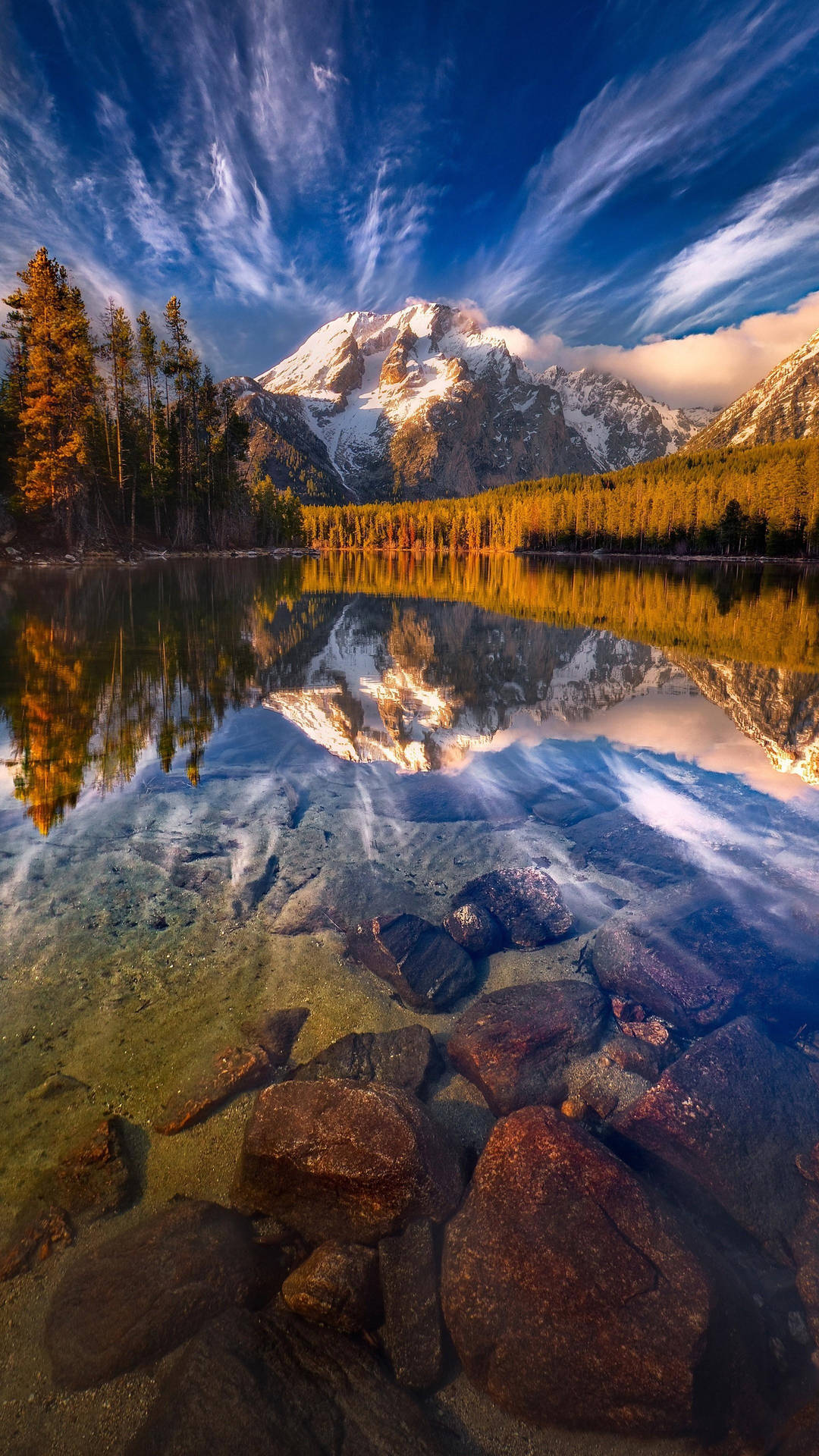 A Lake With Rocks And Mountains In The Background Background