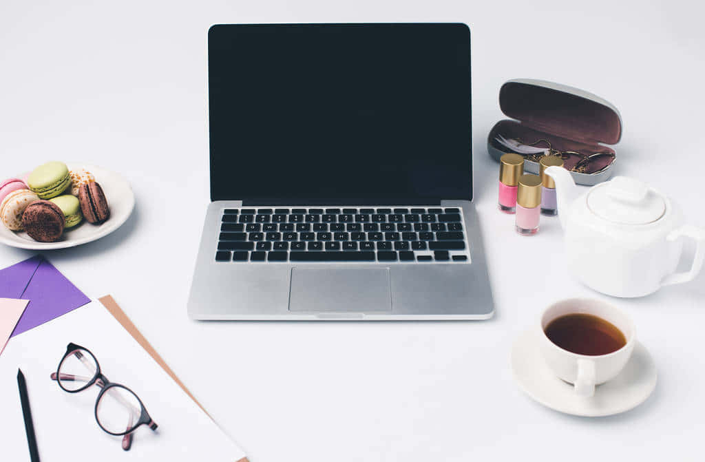 A Laptop, Coffee, And Other Items On A Table Background