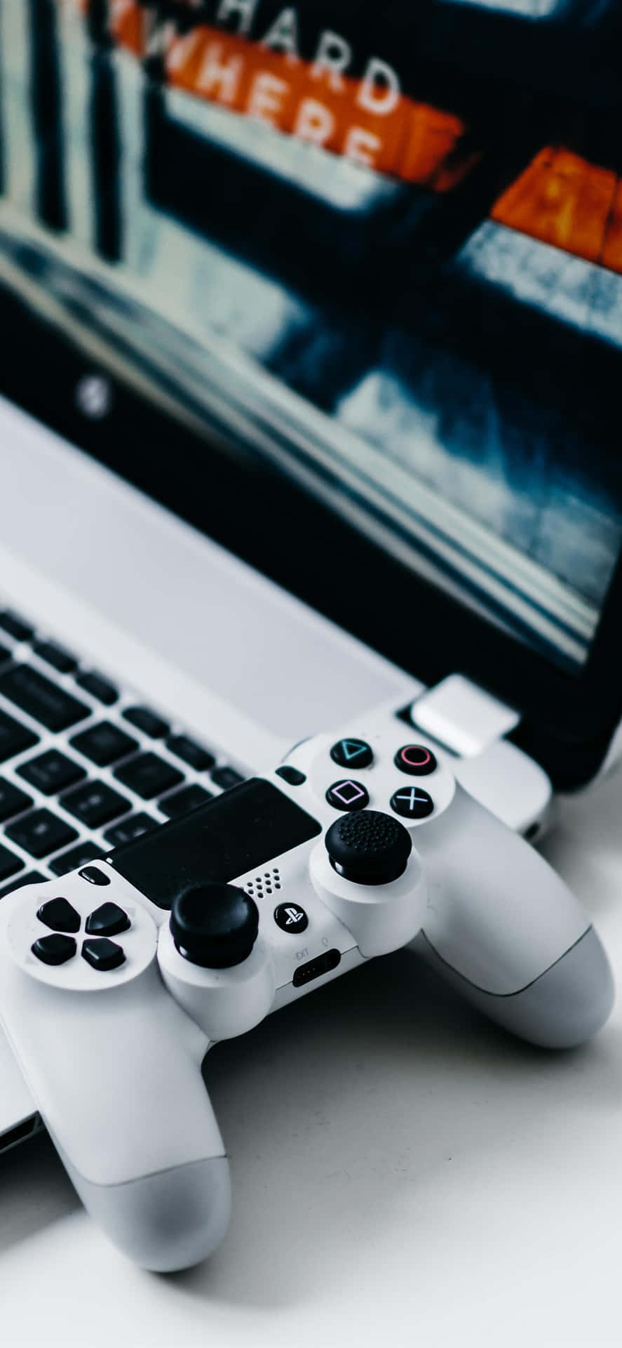 A Laptop Computer With A Game Controller On It Background