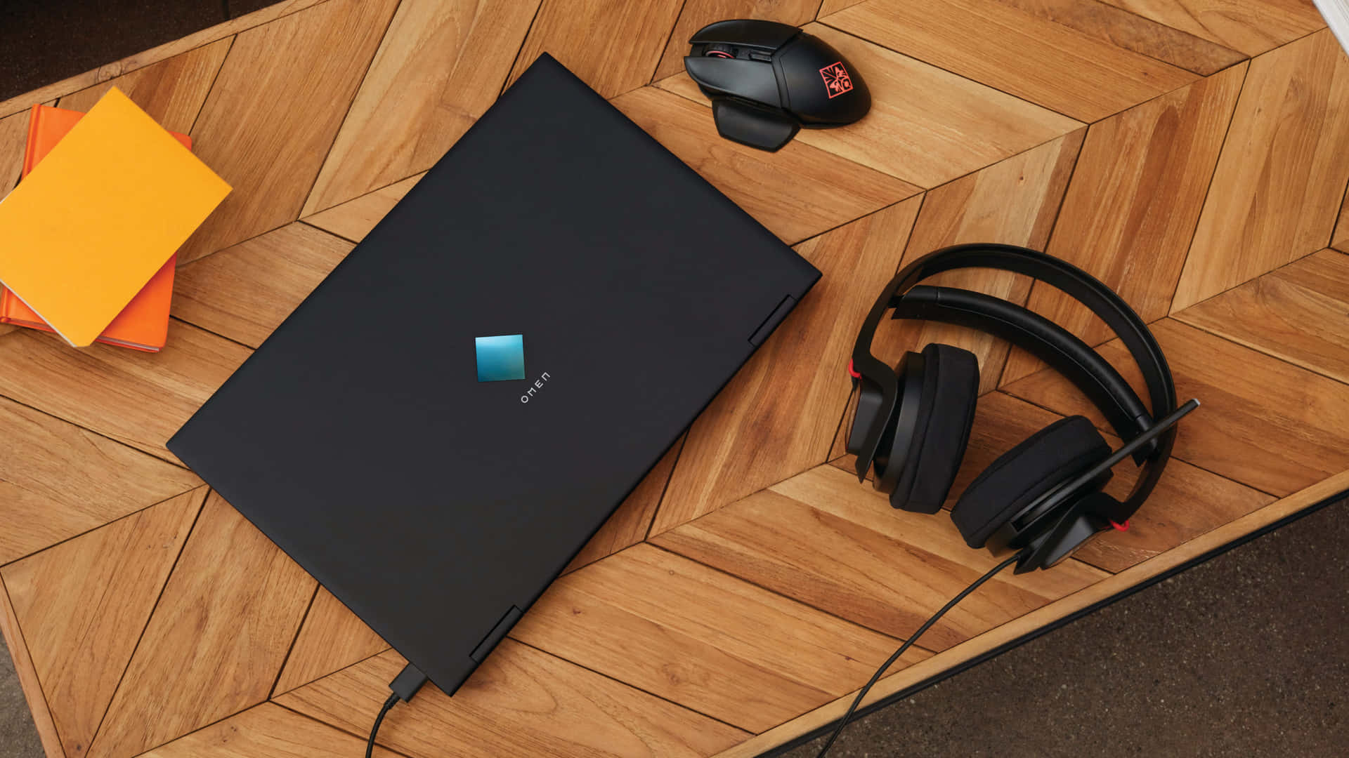 A Laptop, Headphones, And A Mouse On A Wooden Table Background