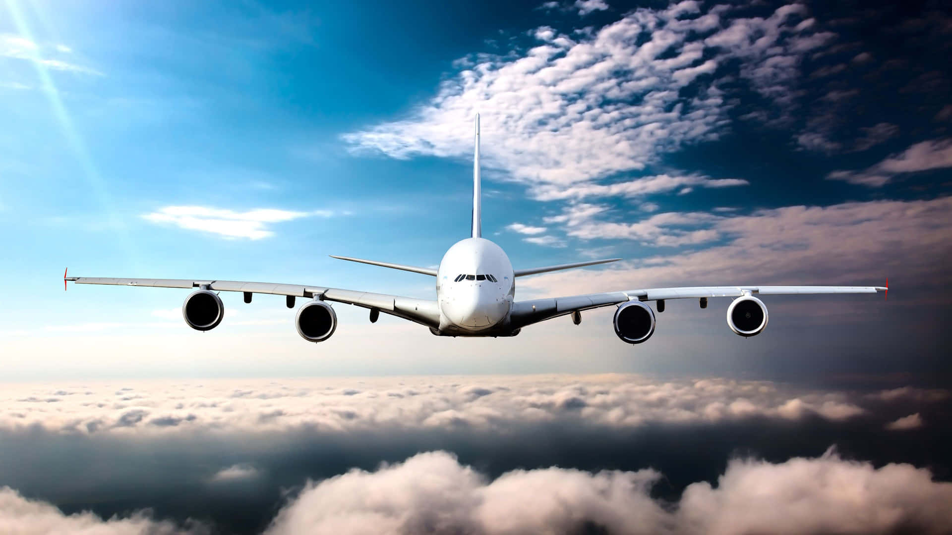 A Large Airplane Flying Through The Clouds Background