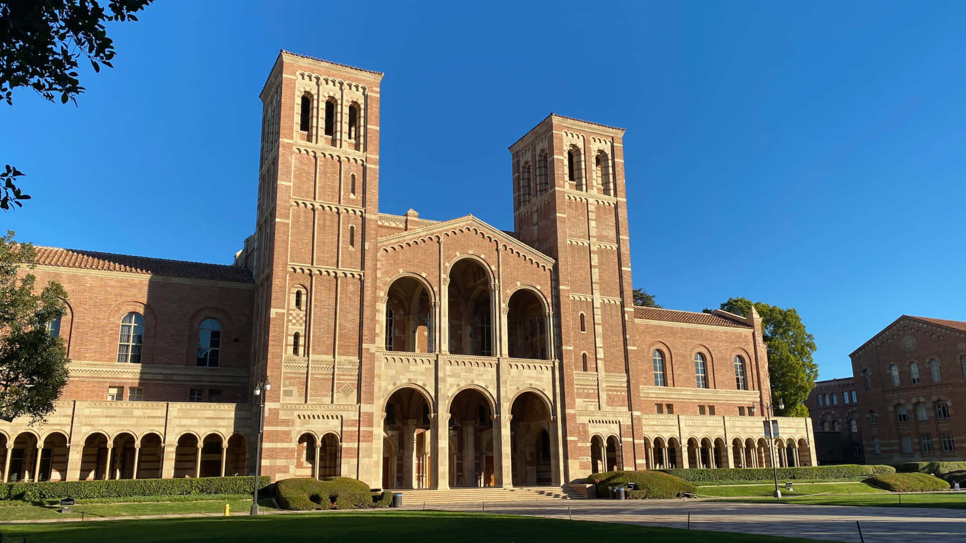 A Large Brick Building With A Large Lawn Background