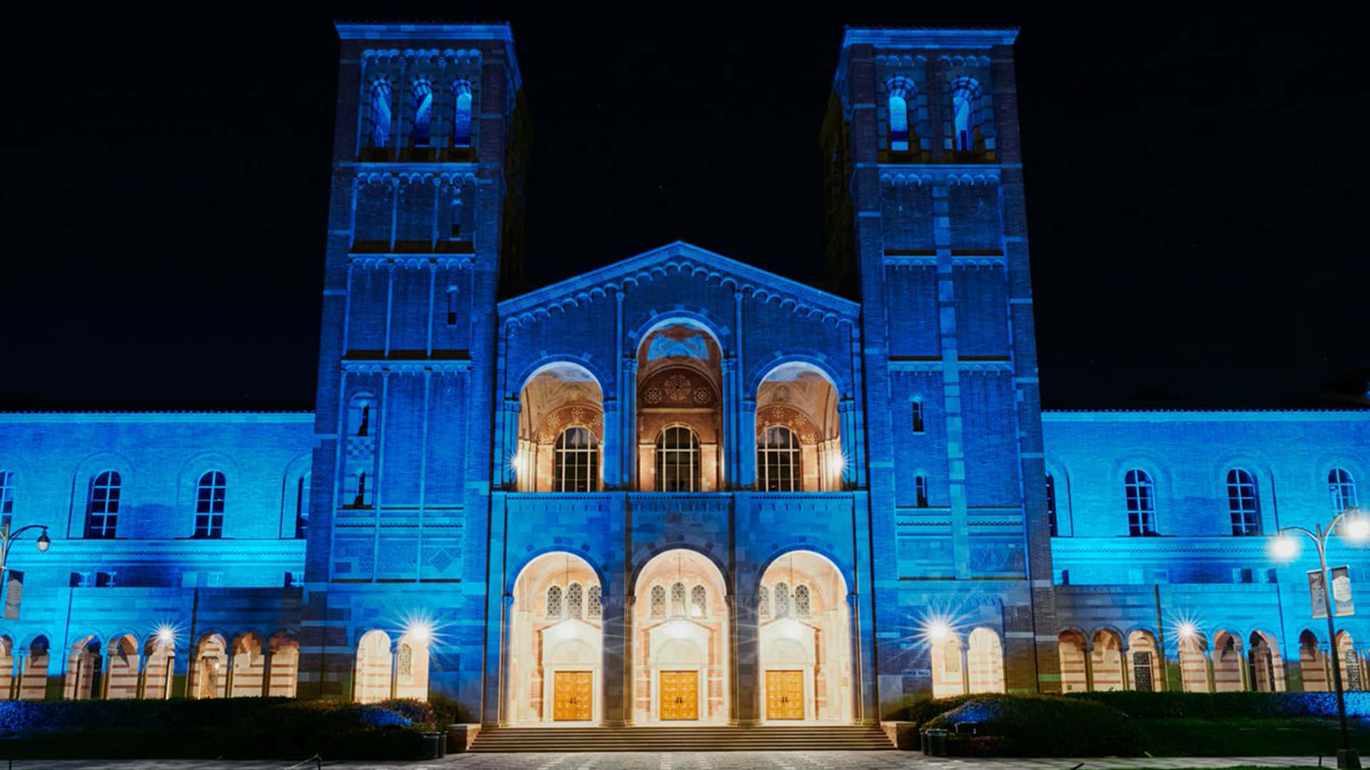 A Large Building Lit Up In Blue Background