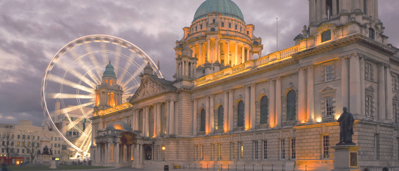 A Large Building With A Ferris Wheel In Front Of It